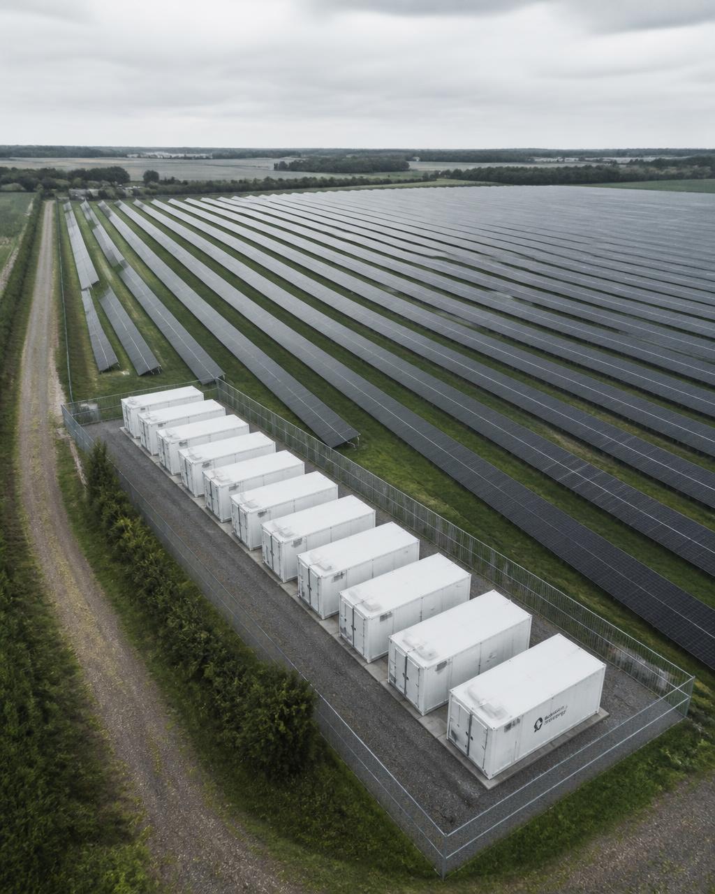 Aerial view of a Danish solar field with integrated battery storage containers